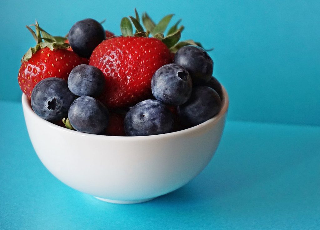 blueberries and strawberries in white ceramic bowl