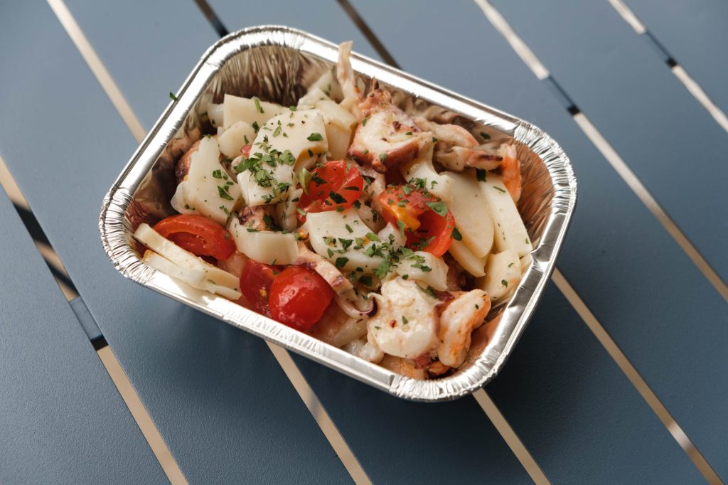 delicious seafood in container on table