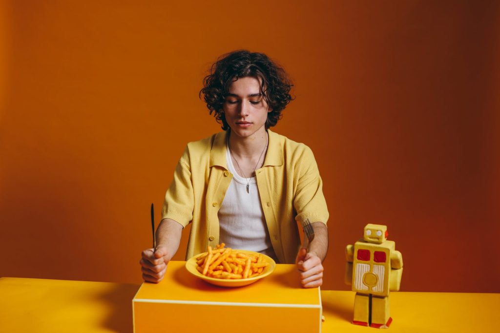 young man looking down on a plate of fries